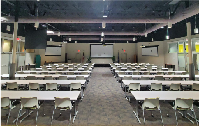 A back-angle view photograph of rows of desks and chairs in the Shangri-La auditorium.